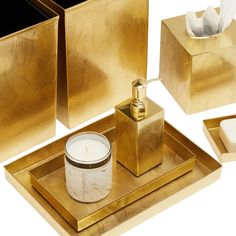 gold bathroom accessories including soap, candle and tissue dispenser