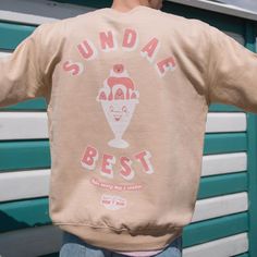 Men's printed sweatshirt with “Sundae Best” slogan and vintage style ice cream sundae graphic. Small logo on front, large back print.Make every day a Sunday in this vintage style ice cream graphic sweater. Slouchy fit. Makes a great gift and a sweet self purchase for summer staycation. All Batch1 products are lovingly designed, printed and packed by hand in the UK at Batch1 HQ.  Our garments are made to order to minimise wastage and printed using water-based, eco-friendly inks. We are committed Nostalgic Crew Neck T-shirt With Graphic Print, Cream Crew Neck T-shirt With Screen Print, Cotton Graphic Print Sweatshirt For Skateboarding, Ice Cream Shirts Graphic Tees, Skateboarding Crew Neck T-shirt With Front Print, Summer Staycation, Women Slogan, Slogan Sweatshirt, Graphic Sweaters