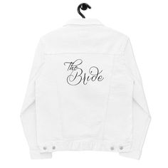 "Wear for the bachelorette party, the honeymoon, or even over the wedding dress in the evening!  This white denim jean jacket with the words \"The Bride\" embroidered on the back is sure to be a hit. * 99% ring-spun combed cotton, 1% spandex * Fabric weight: 12 oz/yd² (407 g/m²) * Chest pockets with buttons" Bride Denim Jacket, Bridal Wardrobe, Embroidered Jean Jacket, White Bride, White Denim Jacket, White Denim Jeans, Personalized Embroidery, Embroidered Jeans, Denim Jean Jacket