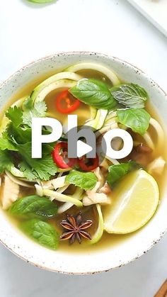 a bowl of pho soup with vegetables and herbs