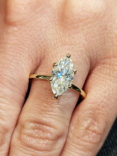 a woman's hand with a diamond ring on top of her finger and an engagement band