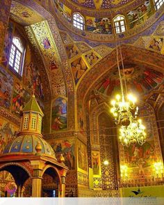 the interior of an ornately decorated church with chandeliers and paintings on the walls