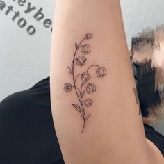 a woman's arm with a flower tattoo on the left side of her arm