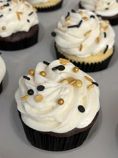 cupcakes with white frosting and gold sprinkles