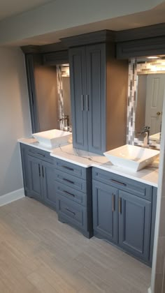 a bathroom with double sinks and two mirrors on the wall next to eachother