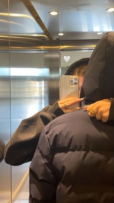 a person wearing a hooded jacket using a cell phone