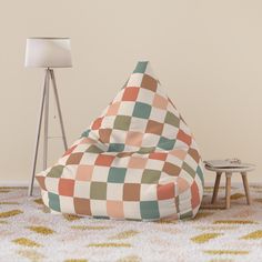 a bean bag chair sitting on top of a rug next to a lamp and table