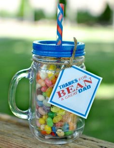 a mason jar filled with candy and a blue straw