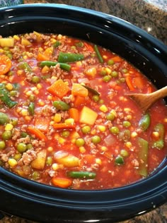 a crock pot filled with meat and vegetables