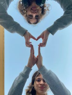 three people making a heart shape with their hands