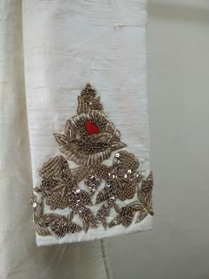 a piece of white cloth with silver and red designs on it