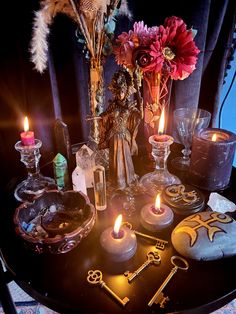 a table topped with lots of different types of candles and other items on top of it