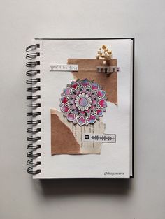 an open notebook with paper and stickers on the pages that have been altered to look like a flower