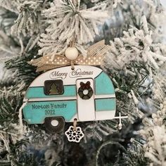 a christmas ornament hanging on a tree in the shape of a camper