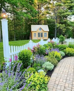 a garden with flowers and a small house in the background