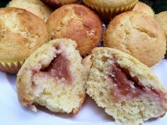 some muffins are on a white plate and have been cut open to show the inside