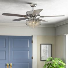 a living room with blue doors and a ceiling fan that is hanging from the ceiling