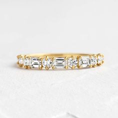 a yellow gold band with five baguettes in the middle and two diamonds on each side