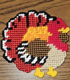 a close up of a small knitted turkey on a wooden table with other items