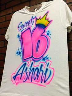 We create custom airbrush t shirts with your design. Personalize our air brush t shirts with your name and colors and we'll create a custom design just for you! 🔹 You can choose to have the design on the Front or Back of your item, and can add a name or short text to the opposite side for $10 more. We'll paint the additional name/text in a fitting style chosen by your artist. ⌚ Delivery Times typically Range from 1-2 weeks! If you need something be a specific date sooner than 2 weeks away, plea Custom Name White Crew Neck T-shirt, White Crew Neck T-shirt With Custom Name, Custom Name T-shirt For Birthday With Crew Neck, Custom Name Crew Neck T-shirt For Birthday, Customizable Pink Short Sleeve Shirt, Custom Name White T-shirt For Birthday, White Short Sleeve T-shirt With Custom Name, Air Brush Shirts, Airbrush Clothes