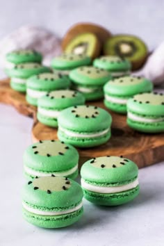 green macaroons are arranged on a wooden tray