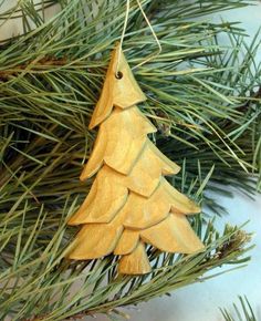 a wooden ornament hanging from a pine tree