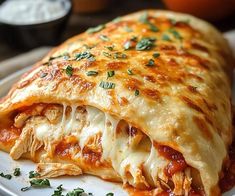 a white plate topped with lasagna covered in sauce and cheese, garnished with parsley