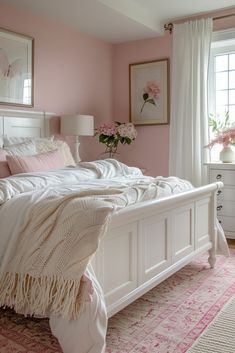 a bedroom with pink walls and white furniture