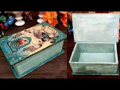 an open box sitting on top of a wooden table next to flowers and vases