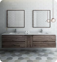 two bathroom sinks with mirrors above them on a tiled floor in front of a white brick wall