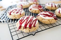 cookies with white and red icing on a cooling rack, ready to be eaten