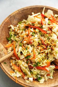 a wooden bowl filled with coleslaw and carrots