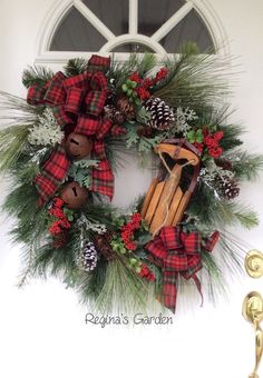 a christmas wreath on the front door with pine cones, cinnamons and other holiday decorations