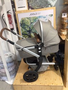 a baby stroller sitting on top of a wooden stand