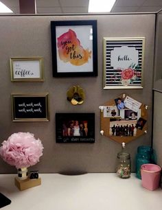 an office cubicle with pictures, photos and flowers on the wall above the desk