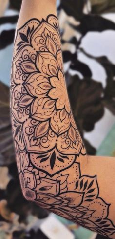 a woman's arm with an intricate tattoo design on the top and bottom half