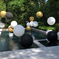 balloons floating in the air near a pool