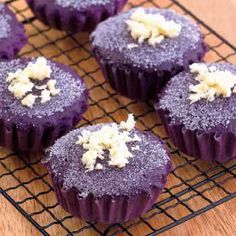 purple cupcakes with white sprinkles on a cooling rack