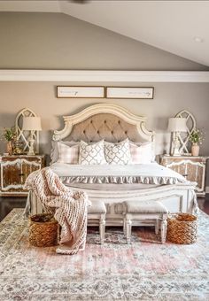 a large white bed sitting on top of a rug in a bedroom next to two nightstands