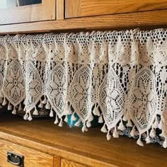 an old lace curtain is hanging on the side of a dresser