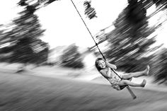 a girl swinging on a rope in the park