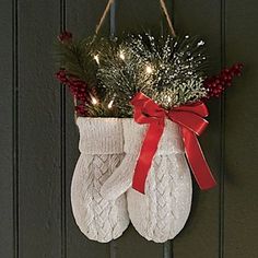 a pair of white socks hanging from a door with christmas lights on it and a red bow