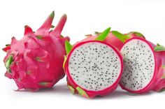 a dragon fruit cut in half and sitting next to it's whole pieces on a white background