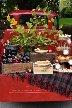 a red truck with food and drinks on it's bed in the back yard