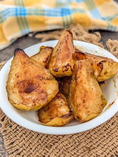 a white plate filled with fried potatoes on top of a tablecloth next to a yellow and blue towel