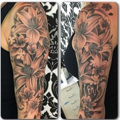 a woman's half sleeve with flowers and butterflies on her left arm in black and grey