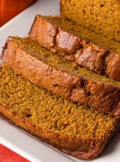 sliced loaf of pumpkin bread on a white plate with an orange napkin in the background