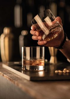 a person holding a glass with some liquid in it