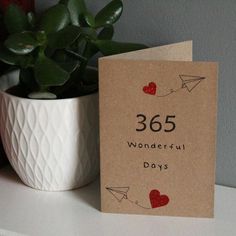 a card that says 350 wonderful days on it next to a potted plant