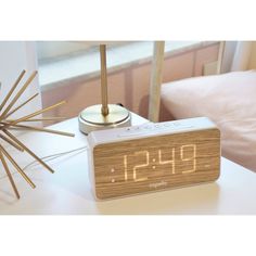 an alarm clock sitting on top of a white table